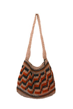 A hand-woven shoulder bag with a zigzag chevron pattern in orange, brown, black, and beige, featuring a single thick woven strap, shown against a plain white background.
